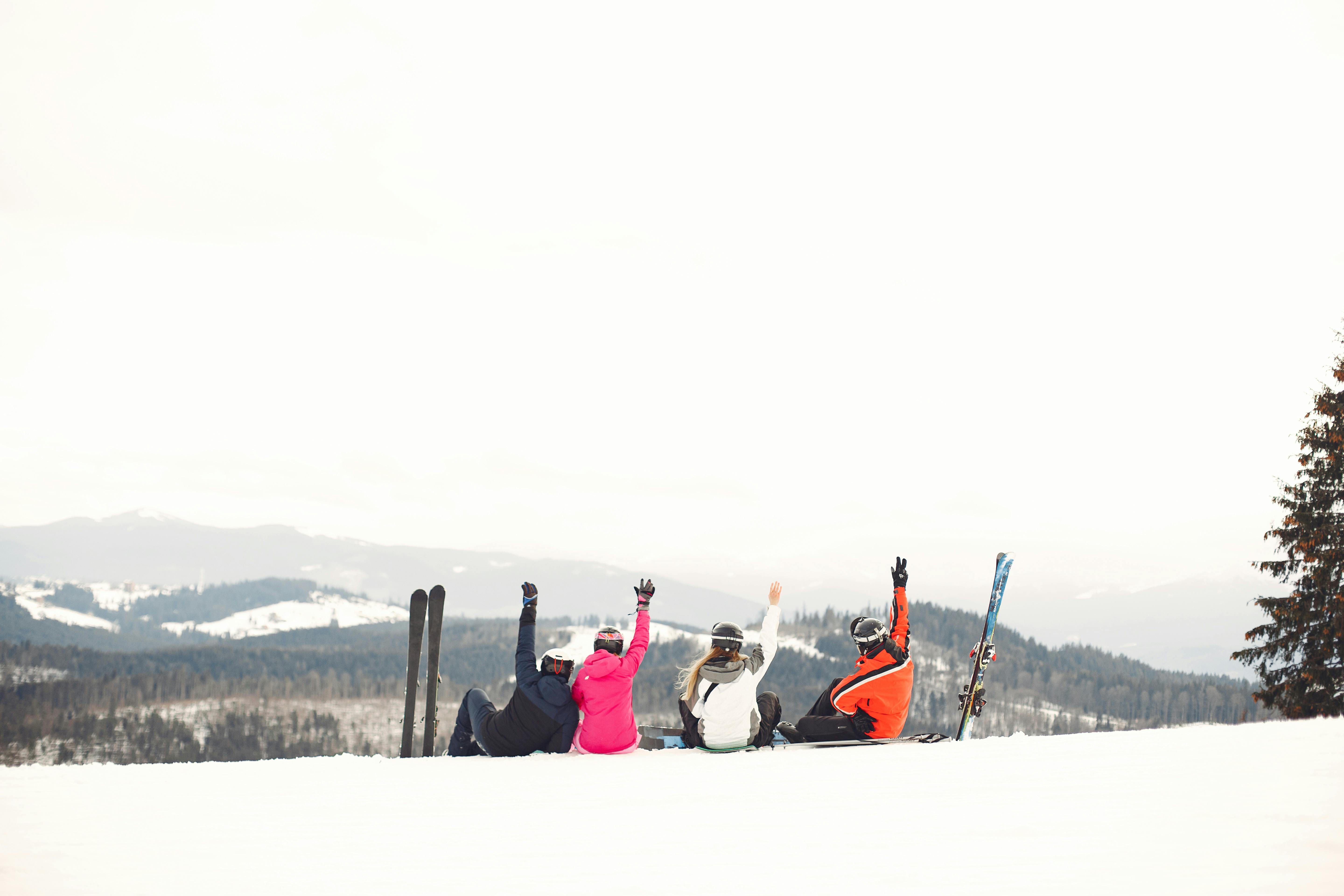 Skiers sitting on a ski lift overlooking a snowy mountain resort